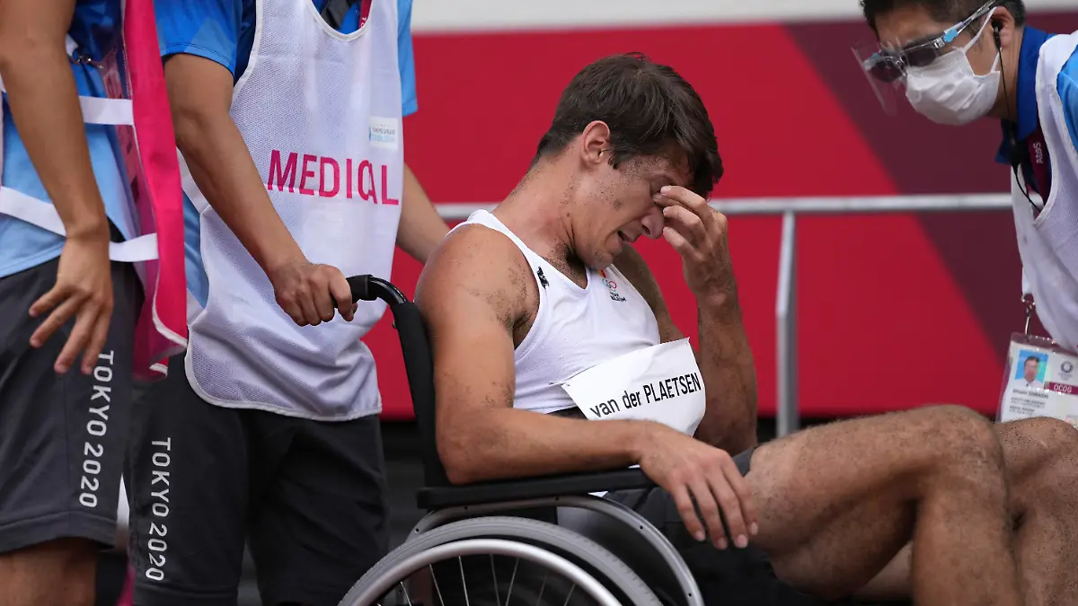 04.08.2021, Japan, Tokio: Leichtathletik: Olympia, Zehnkampf, Männer, Weitsprung im Olympiastadion. Thomas Van Der Plaetsen (M) aus Belgien sitzt nach einem Sturz in einem Rollstuhl und wird medizinisch betreut. Foto: Matthias Schrader/AP/dpa +++ dpa-Bildfunk +++