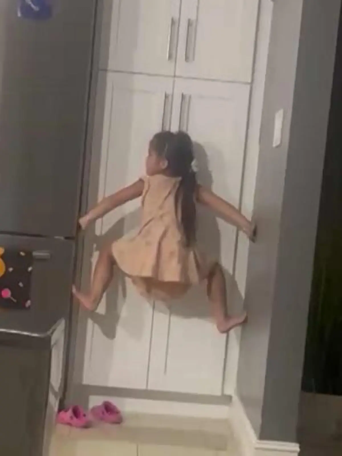 Die fünfjährige Emily klettert zwischen den Wänden hoch, um an ihr Spielzeug zu kommen.
