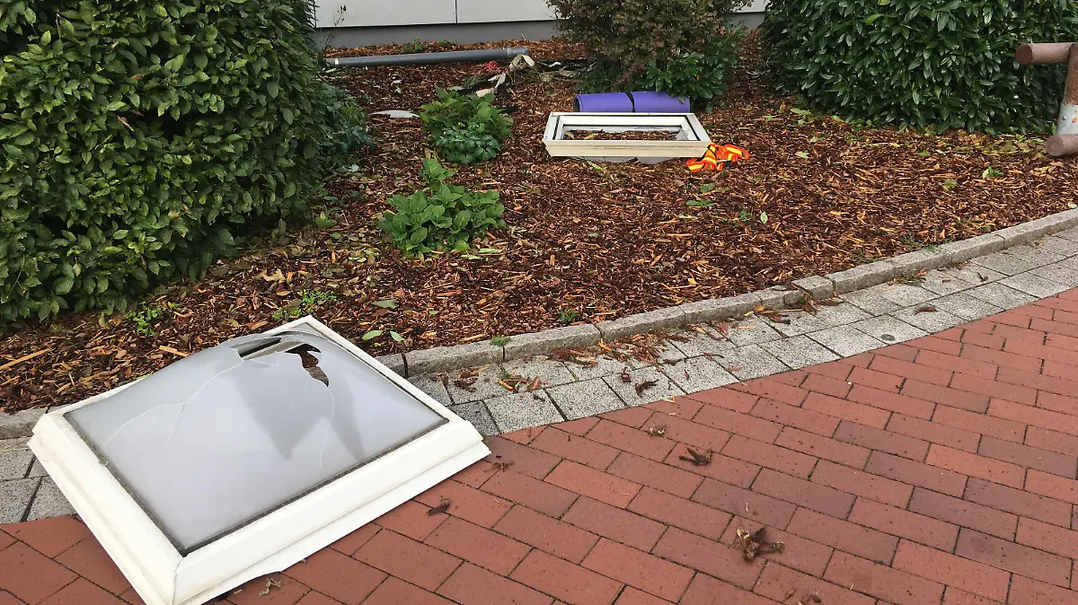 Die kaputten Oberlichter liegen im Vorgarten der Turnhalle.