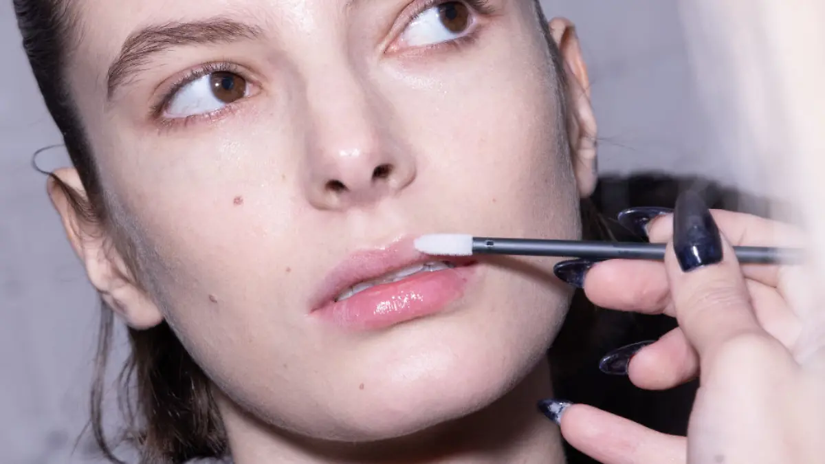 Frau bekommt Lippen geschminkt