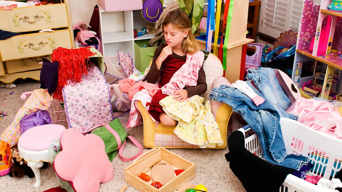 Mädchen sitzt in ihrem unordentlichen Kinderzimmer