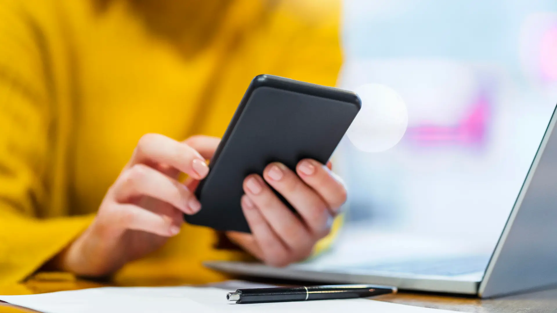 Hands of businesswoman using smart phone at table in cafe || Modellfreigabe vorhanden