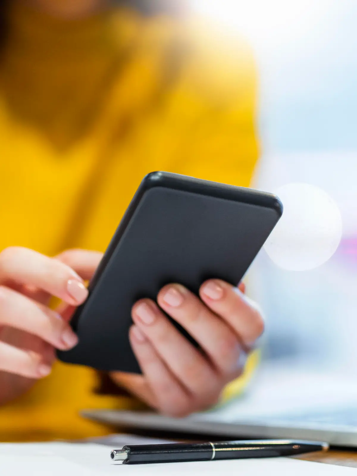 Hands of businesswoman using smart phone at table in cafe || Modellfreigabe vorhanden