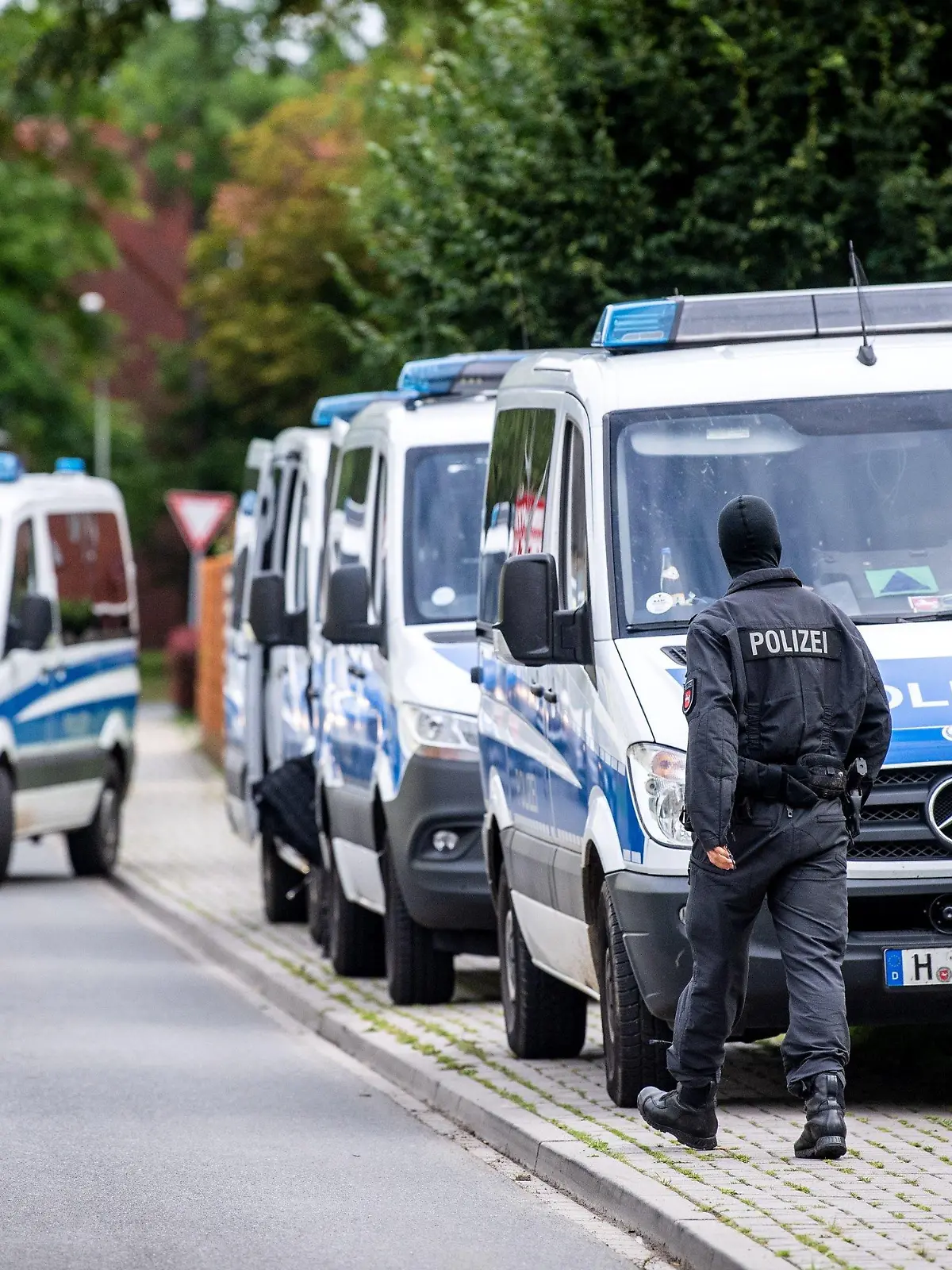 03.08.2021, Niedersachsen, Wilhelmshaven: Einsatzkräfte der Polizei kommen mit ihren Fahrzeugen in einem Wohnviertel an. Mehrere hundert Beamte durchsuchen im Stadtgebiet mehr als 30 Objekte. Die Durchsuchungen werden wegen des Verdachts, gewerbsmäßig mit Betäubungsmitteln zu handeln, durchgeführt. Foto: Sina Schuldt/dpa +++ dpa-Bildfunk +++