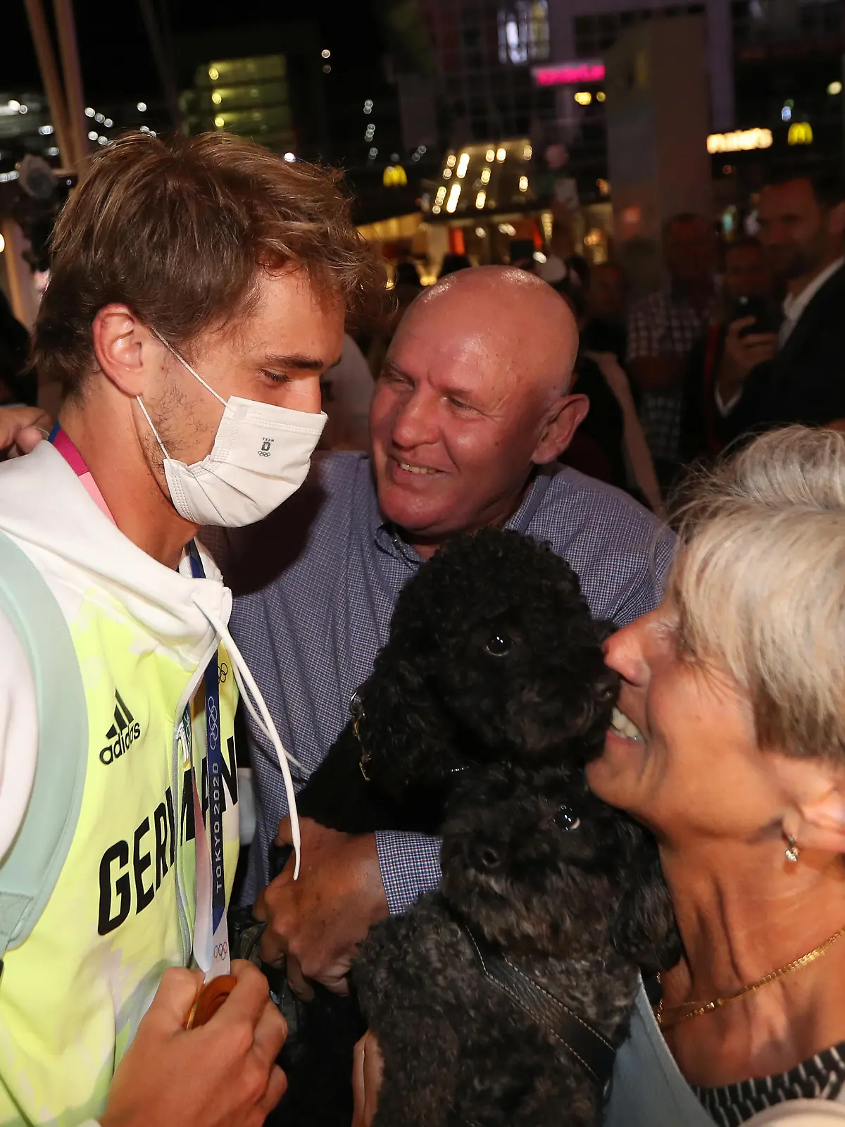 MUNICH, GERMANY - AUGUST 02: German tennis player and Tokyo 2020 gold medalist Alexander Zverev (L) is hugged by his parents during his arrival at Airport Munich on August 02, 2021 in Munich, Germany. (Photo by Alexandra Beier/Getty Images)