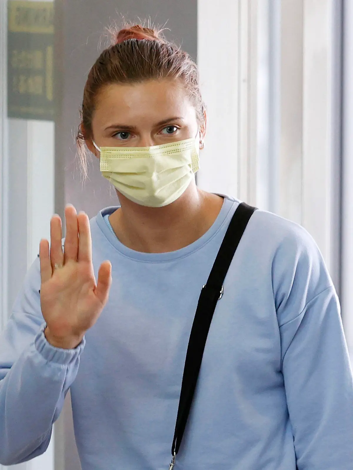 04.08.2021, Japan, Narita: Olympia-Sprinterin Kristina Timanowskaja aus Belarus winkt am internationalen Flughafen Narita östlich von Tokio an. Timanowskaja plant in Europa Zuflucht zu suchen. Der Fall der Leichtathletin hatte bei den Olympischen Spielen für internationale Empörung gesorgt. Nach Angaben der Athletin wollten belarussische Behörden sie zur vorzeitigen Rückkehr nach Minsk zwingen, weil sie Kritik an Sportfunktionären geübt hatte. Foto: Uncredited/Kyodo News/dpa +++ dpa-Bildfunk +++