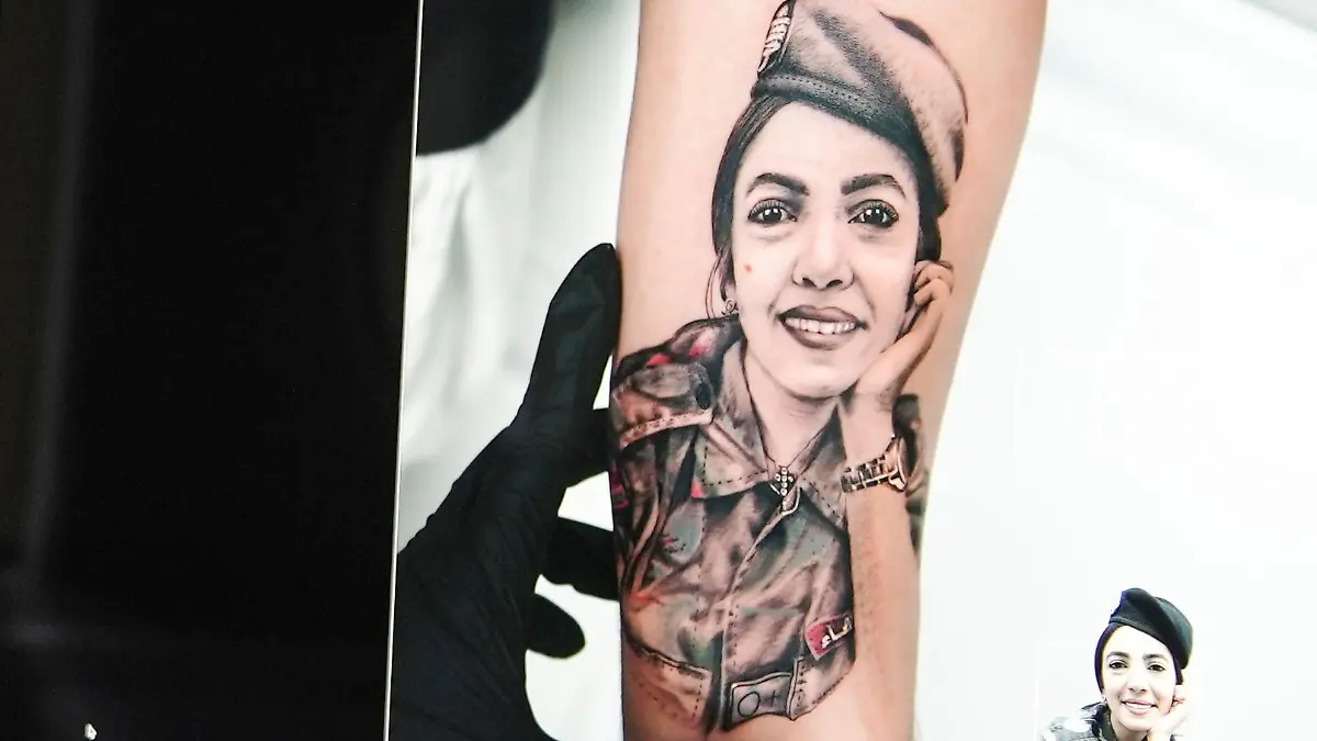 Joa Antoun, a tattoo artist, works on a drawing of Sahar Fares, a Firefighter who was a victim of last year's Beirut port blast, in Beirut, Lebanon July 15, 2021. Picture taken July 15, 2021. REUTERS/Issam Abdallah
