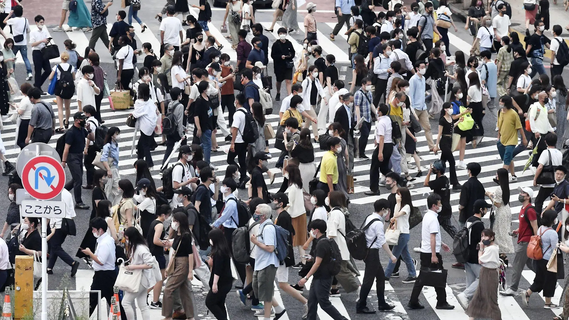 30.07.2021, Japan, Tokio: Passanten mit Mund-Nasen-Schutz gehen über eine belebte Kreuzung im Stadtteil Shibuya. Japan hat wegen stark gestiegener Corona-Infektionen den Notstand für die Olympia-Stadt Tokio abermals verlängert und auf weitere Präfekturen ausgeweitet. Foto: --/kyodo/dpa +++ dpa-Bildfunk +++