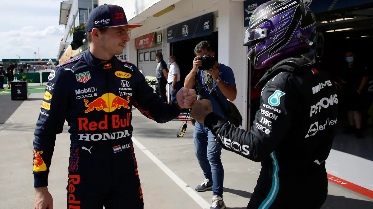 Mercedes driver Lewis Hamilton of Britain, right, after setting a pole position fist bumps with third placed Red Bull driver Max Verstappen of the Netherlands after the qualifying session for the Hungarian Formula One Grand Prix, at the Hungaroring racetrack in Mogyorod, Hungary, Saturday, July 31, 2021. The Hungarian Formula One Grand Prix will be held on Sunday. (David W Cerny/Pool via AP)