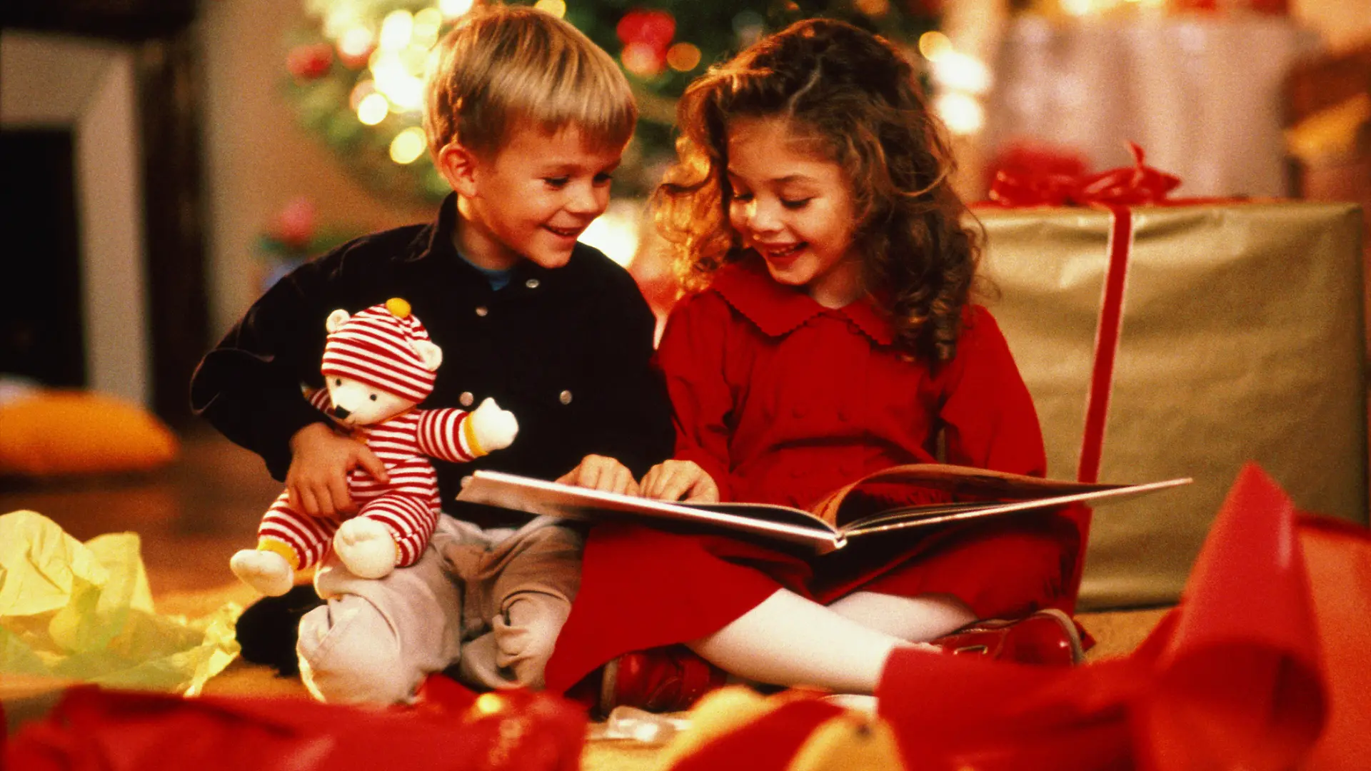 Kinder lesen ein Kinderbuch an Weihnachten.