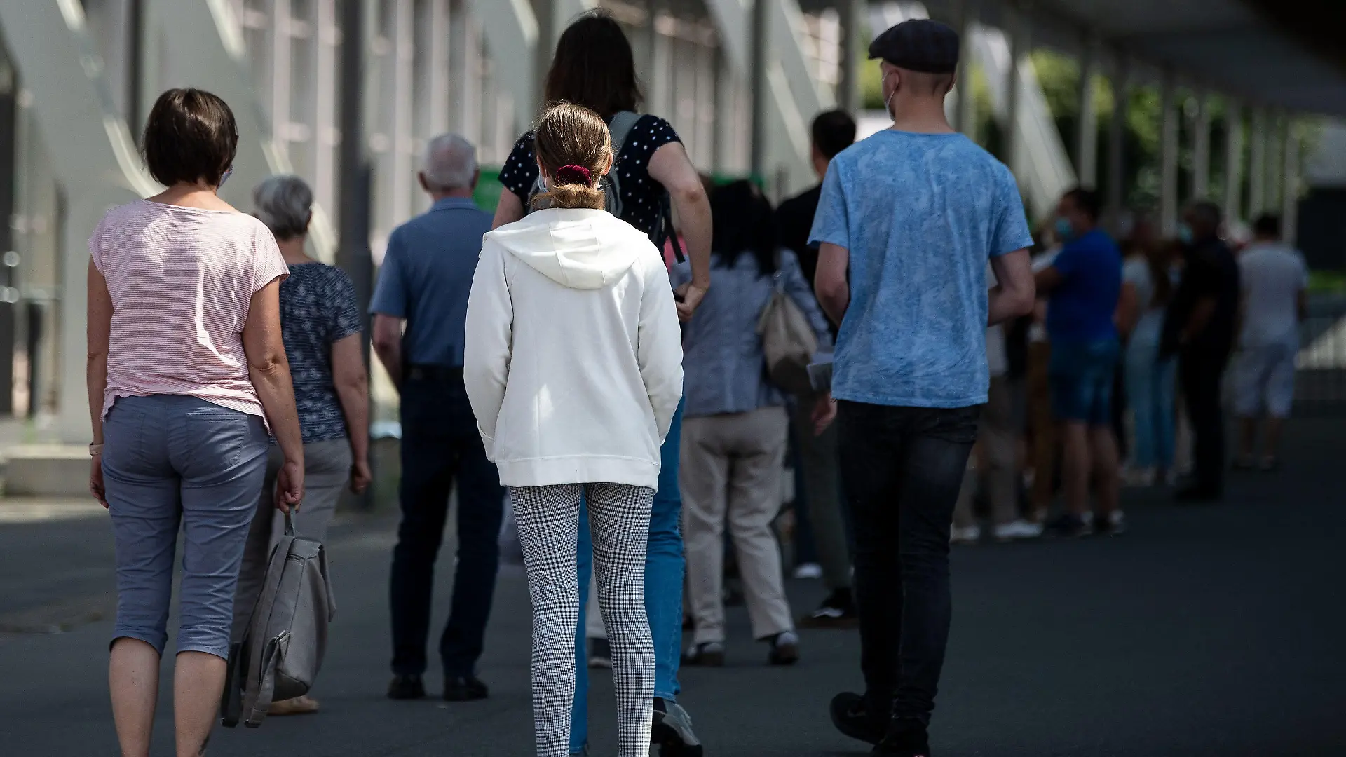 18.07.2021, Niedersachsen, Hannover: Impflinge stehen am Eingang vom Impfzentrum auf dem Messegelände in einer Schlange. Bei einer landesweiten Impfaktion für Kinder und Jugendliche wurden rund 27 000 Impfdosen gegen das Coronavirus für den Aktionstag reserviert. Foto: Swen Pförtner/dpa +++ dpa-Bildfunk +++