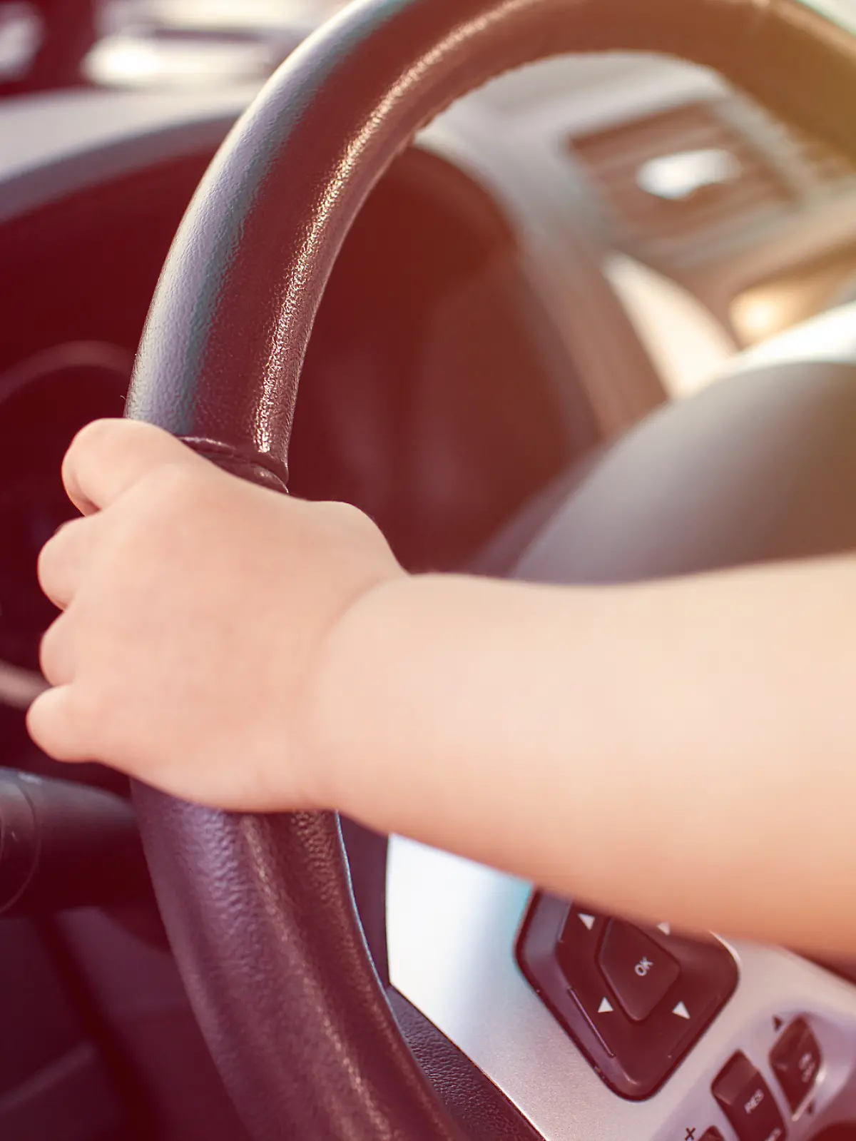 Kinderhände am Lenkrad eines Autos (Symbolfoto)