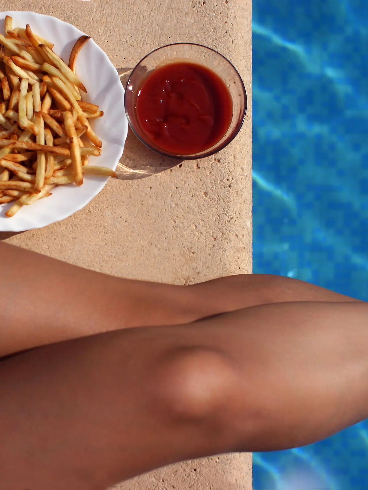 Frau mit Pommes im Schwimmbad