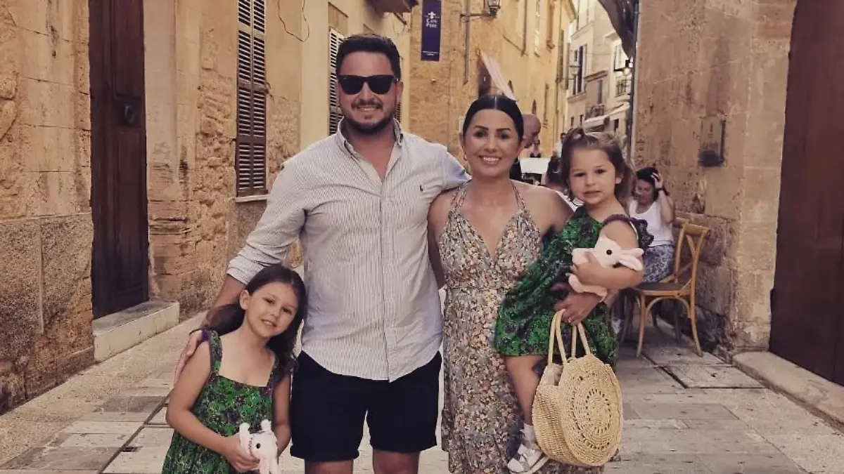 Mallorca (Spanien): Die Vierköpfige Familie Dunion im Urlaub. Sie stehen in einer Gasse in Alcúdia und lächeln in die Kamera.
