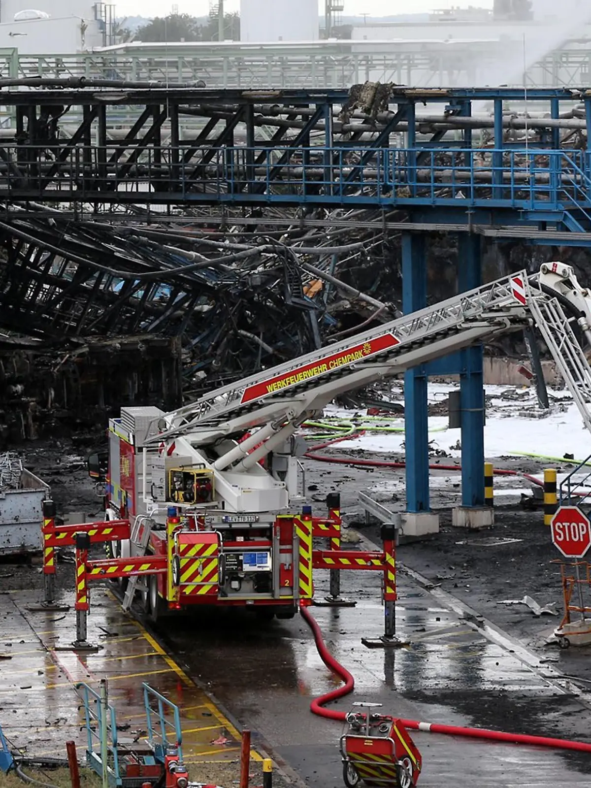 HANDOUT - 28.07.2021, Nordrhein-Westfalen, Leverkusen: Einsatzkräfte der Feuerwehr sind mit Löscharbeiten im Chempark beschäftigt. Nach der Explosion in einer Müllverbrennungsanlage am Vortag geht die Suche nach den Vermissten weiter. Foto: Chempark/Currenta GmbH - ACHTUNG: Nur zur redaktionellen Verwendung im Zusammenhang mit der aktuellen Berichterstattung und nur mit vollständiger Nennung des vorstehenden Credits +++ dpa-Bildfunk +++