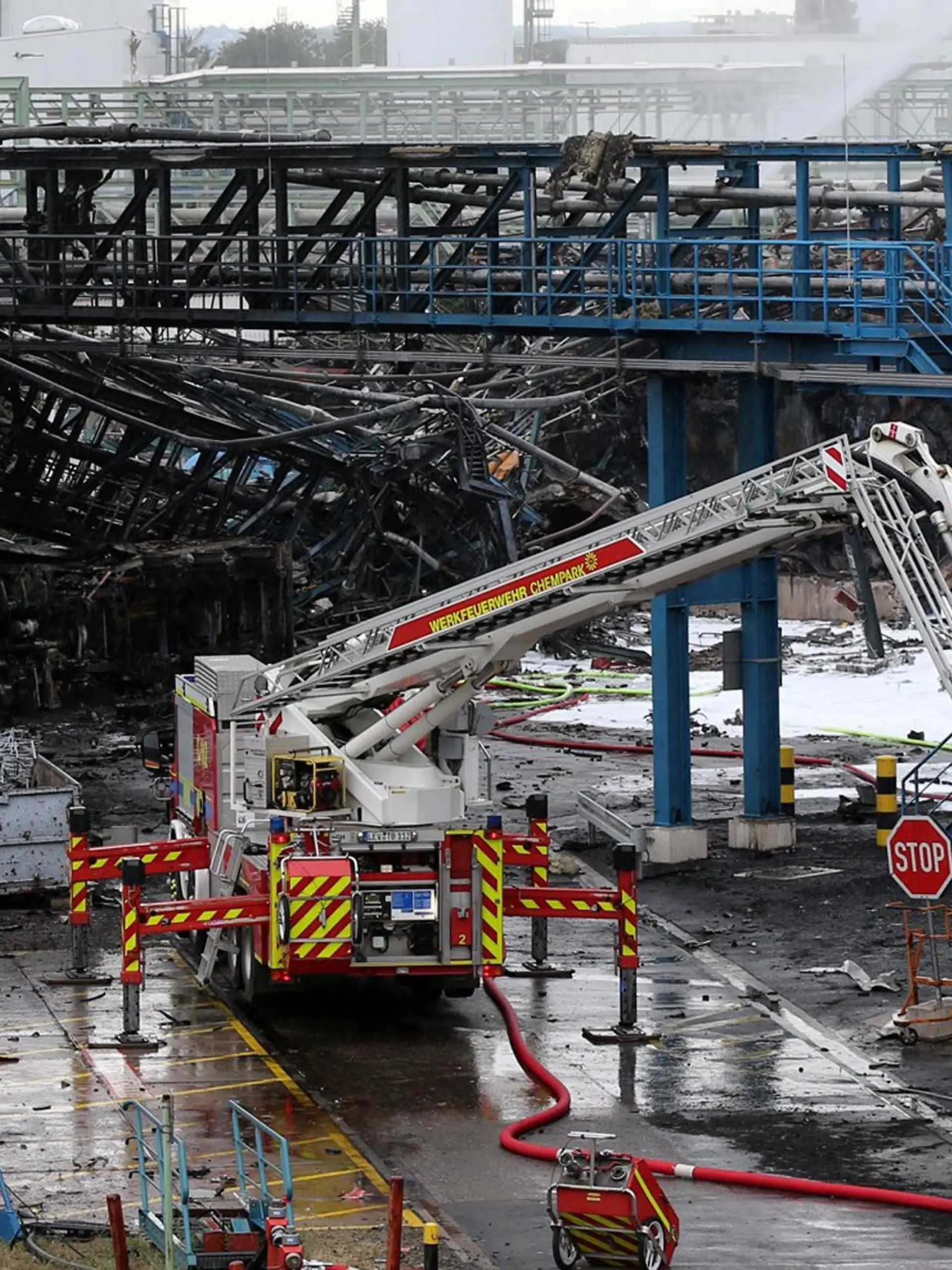 HANDOUT - 28.07.2021, Nordrhein-Westfalen, Leverkusen: Einsatzkräfte der Feuerwehr sind mit Löscharbeiten im Chempark beschäftigt. Nach der Explosion in einer Müllverbrennungsanlage am Vortag geht die Suche nach den Vermissten weiter. Foto: Chempark/Currenta GmbH - ACHTUNG: Nur zur redaktionellen Verwendung im Zusammenhang mit der aktuellen Berichterstattung und nur mit vollständiger Nennung des vorstehenden Credits +++ dpa-Bildfunk +++