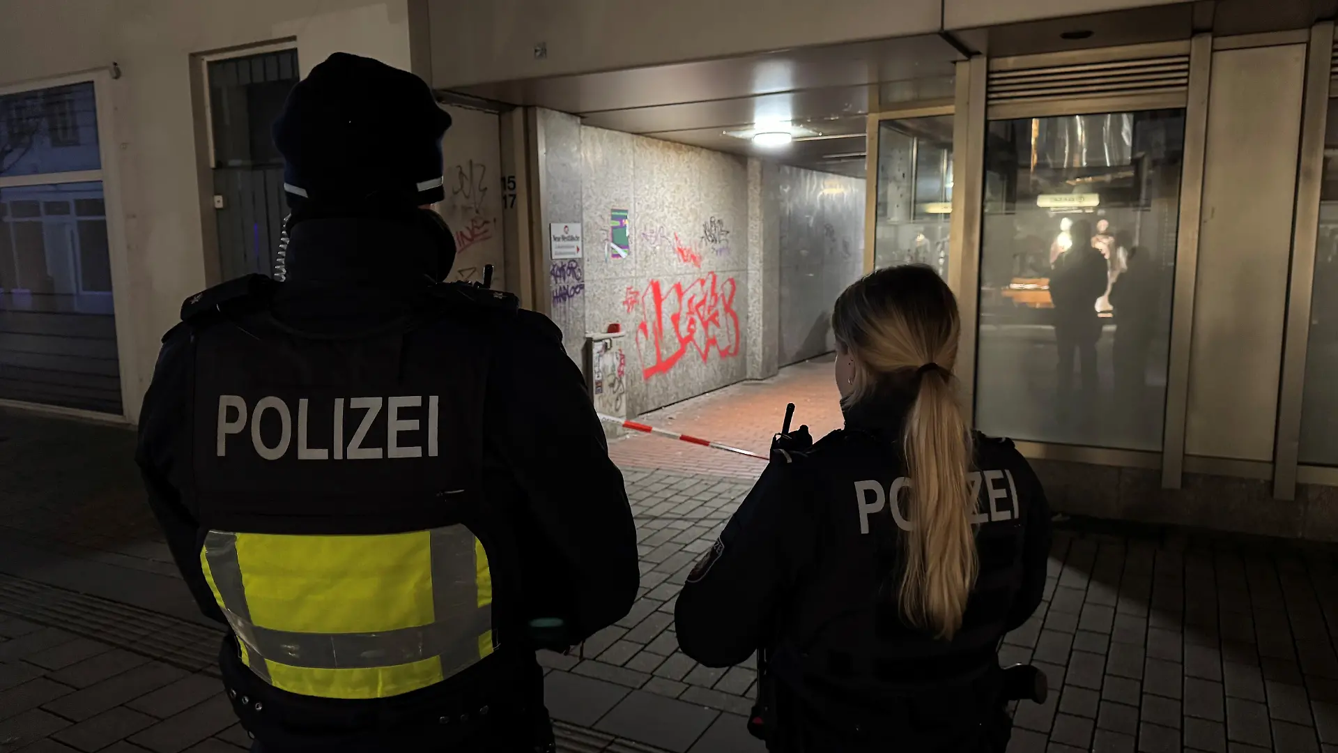 dpatopbilder - 11.12.2025, Herford: Polizisten stehen an einem Flatterband. Ein 16-Jähriger ist im ostwestfälischen Herford bei einem Messerangriff lebensgefährlich verletzt worden. Der Vorfall habe sich in einer Seitenstraße am Rande des Weihnachtsmarkts ereignet, teilte ein Sprecher der Polizei mit. Foto: Christian Müller/dpa +++ dpa-Bildfunk +++