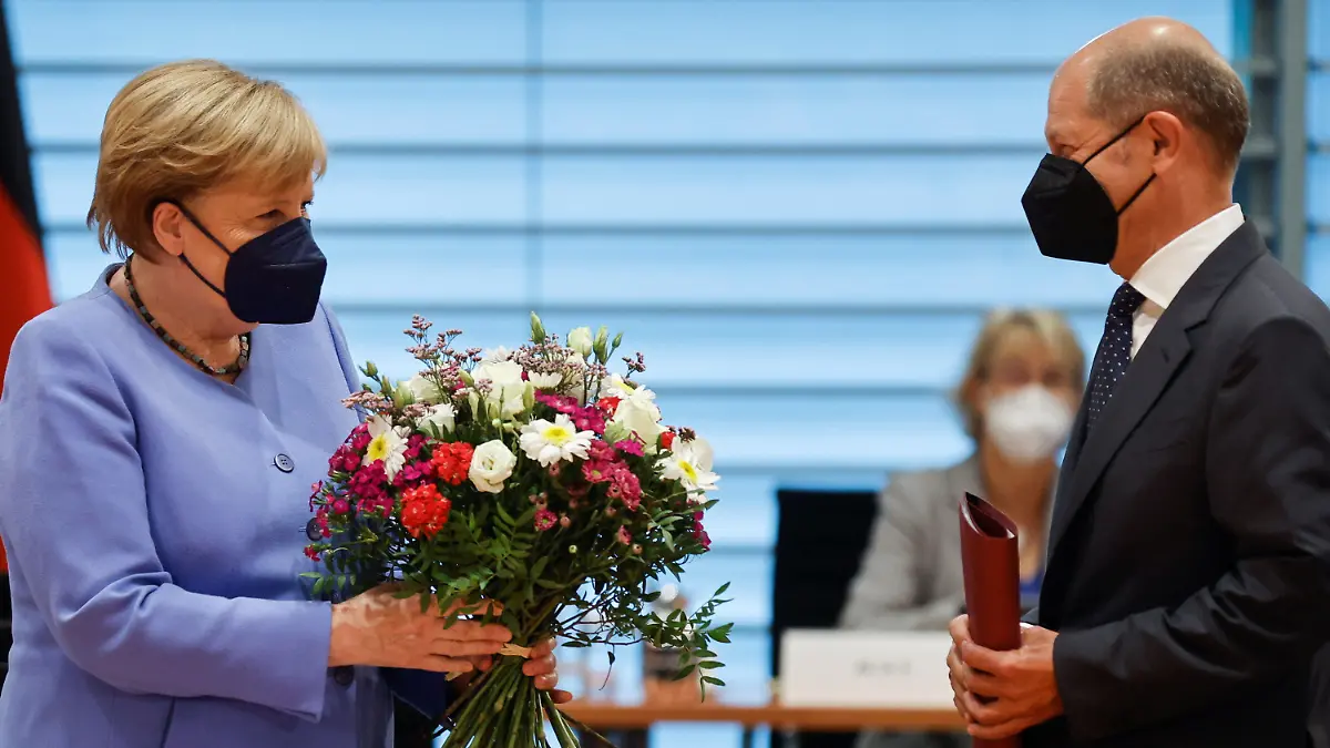 21.07.2021, Berlin: Bundesfinanzminister Olaf Scholz (SPD) steht vor der Kabinettssitzung neben Bundeskanzlerin Angela Merkel (CDU), nachdem er ihr anlässlich ihres Geburtstages am 17. Juli einen Blumenstrauß überreicht hat. Foto: Axel Schmidt/Reuters/Pool/dpa +++ dpa-Bildfunk +++