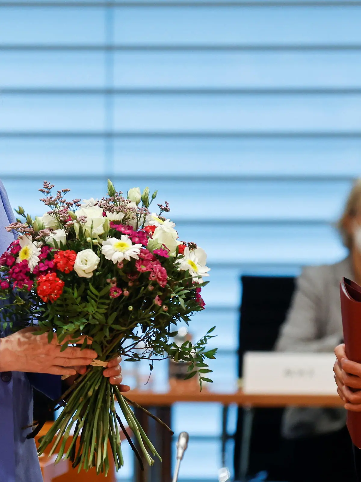21.07.2021, Berlin: Bundesfinanzminister Olaf Scholz (SPD) steht vor der Kabinettssitzung neben Bundeskanzlerin Angela Merkel (CDU), nachdem er ihr anlässlich ihres Geburtstages am 17. Juli einen Blumenstrauß überreicht hat. Foto: Axel Schmidt/Reuters/Pool/dpa +++ dpa-Bildfunk +++