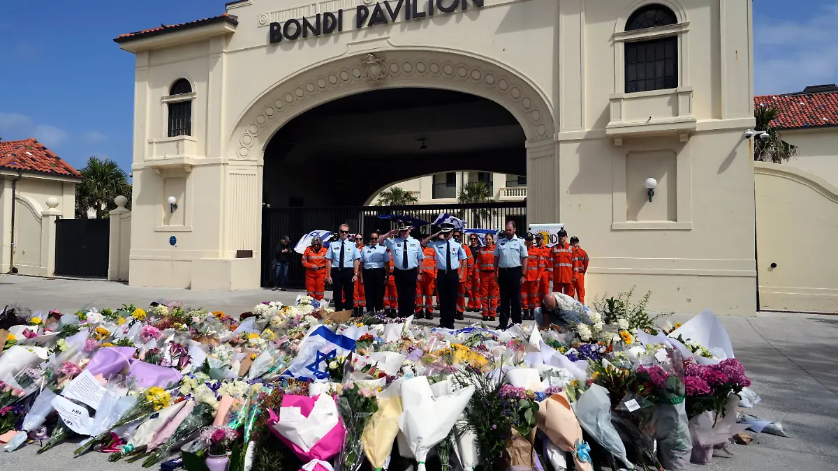 Polizisten salutieren nach der Kranzniederlegung an einer Gedenkstätte für die Opfer des Angriffs vor dem Bondi Pavilion am Bondi Beach in Sydney