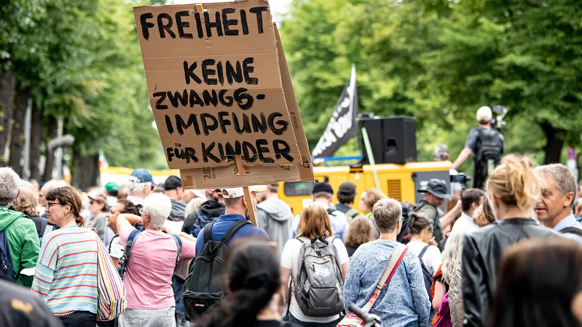 01.08.2021, Berlin: Demonstranten, u.a. mit einem Schild "Freiheit keine Zwangsimpfung für Kinder" nehmen an einer unangemeldeten Demo gegen die Corona-Maßnahmen trotz Demonstrationsverbot teil. Mehrere Demonstrationen der in Berlin bleiben am Sonntag verboten, darunter eine Kundgebung der Stuttgarter «Querdenken»-Initiative. Foto: Fabian Sommer/dpa +++ dpa-Bildfunk +++