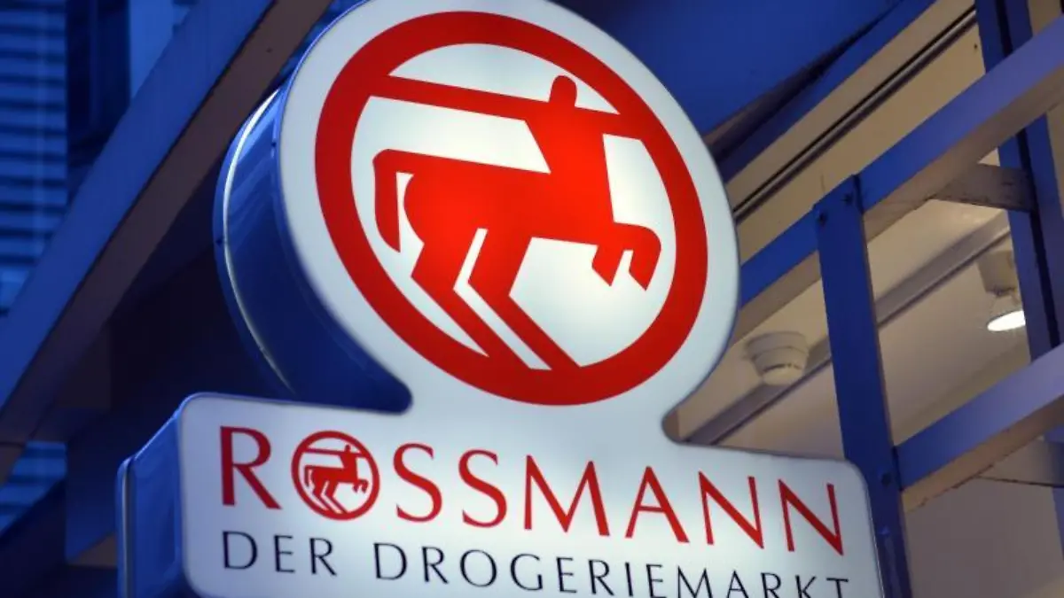 Ein Schild mit dem Logo von Rossmann leuchtet an einer Filiale