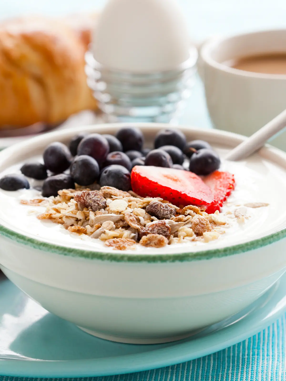 Ein gesundes Frühstück mit Müsli mit Joghurt, Obst, gekochtem Ei und Orangensaft