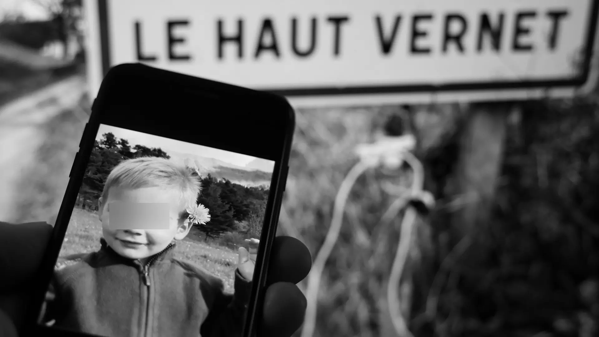 Foto von Émile auf einem Handy vor dem Ortsschild von Le Vernet, wo er verschwand