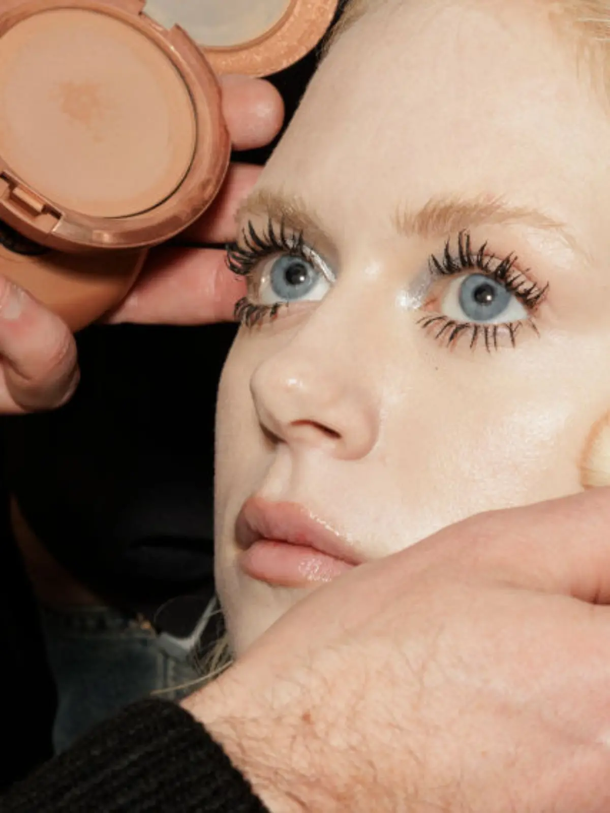 Blonde Frau wird geschminkt