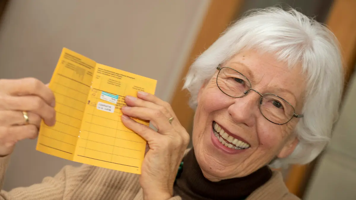 23.01.2021, Baden-Württemberg, Ulm: Seniorin Ursula Neuberger hält ihren Impfpass, in dem eine Grippe-Impfung (oben) und ihre erste Corona-Impfung vermerkt sind. Die meisten Menschen über 80 Jahre leben in Deutschland zu Hause. Sie müssen sich selbst um eine Impfung kümmern. Probleme mit der Hotline oder Überforderung bei der Online-Anmeldung stellen viele Senioren und ihre Angehörigen vor Probleme. (zu dpa "Senioren mit Hürden auf dem Weg zur Corona-Impfung") Foto: Stefan Puchner/dpa +++ dpa-Bildfunk +++