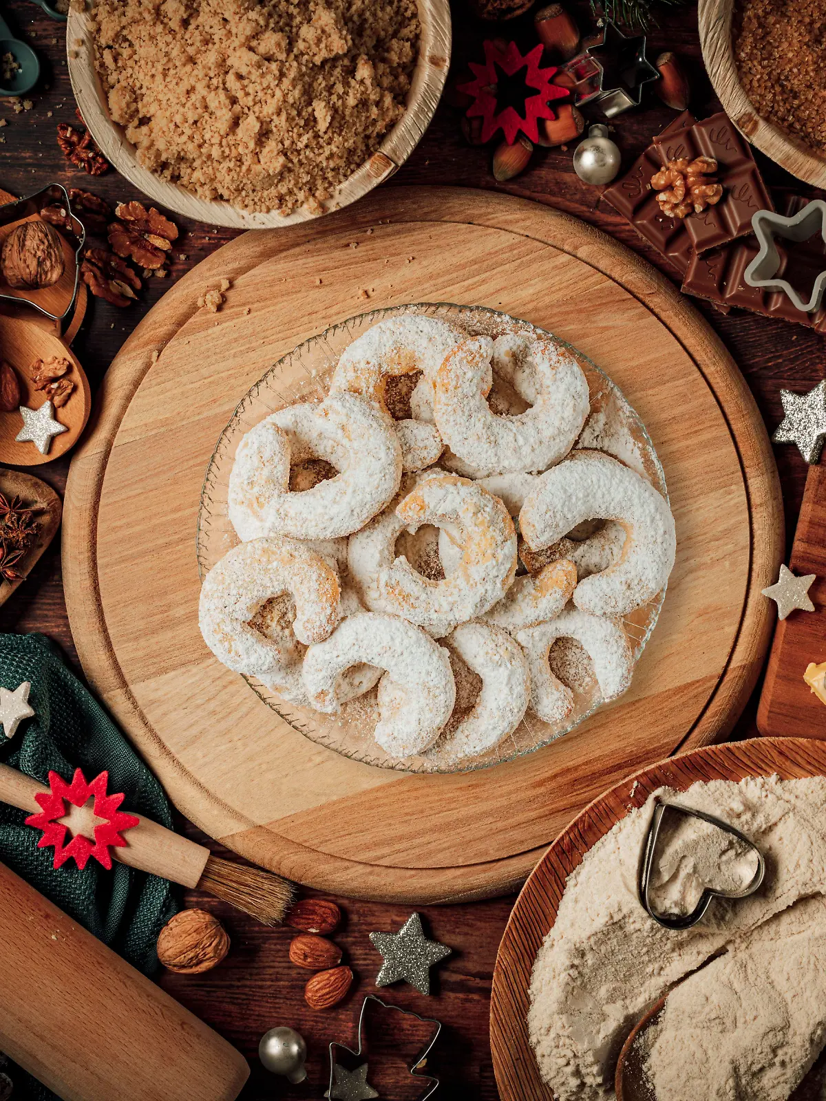 Teller mit Vanillekipferl, Backzutaten, Weihnachtsdeko, Mehl, Zucker, Mandeln, Nüsse, Zimt, Ausstechformen 