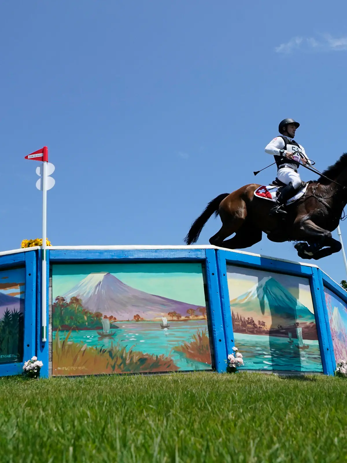Switzerland's Robin Godel, riding Jet Set, competes during the Equestrian Eventing Cross Country competition at the Sea Forest Cross Country Course during the 2020 Summer Olympics, Sunday, Aug. 1, 2021, in Tokyo, Japan. The Swiss Olympic team says the horse had to be euthanized after sustaining a leg injury in the team eventing competition. (AP Photo/Carolyn Kaster)