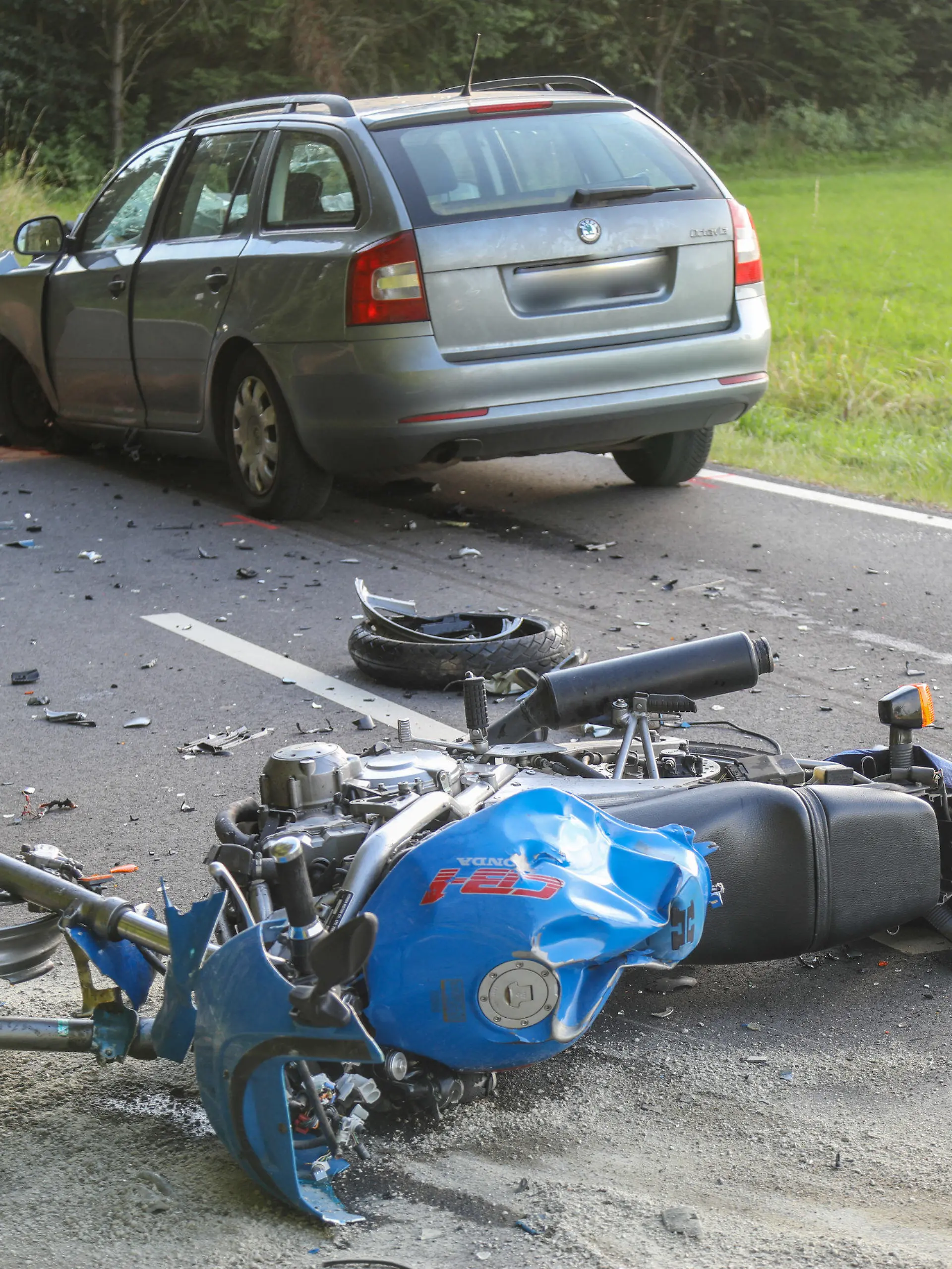 31.07.2021, Hessen, Grebenhain: Ein Motorrad und ein Auto stehen nach einem Unfall auf der Straße. der Motorradfahrer war auf der Kreisstraße 250 zwischen Metzlos und Nieder-Moos (Vogelsbergkreis) auf die Gegenfahrbahn geraten und dort frontal mit einem Auto zusammengestoßen, wie die Polizei mitteilte. Foto: FULDAMEDIA/düa/dpa +++ dpa-Bildfunk +++