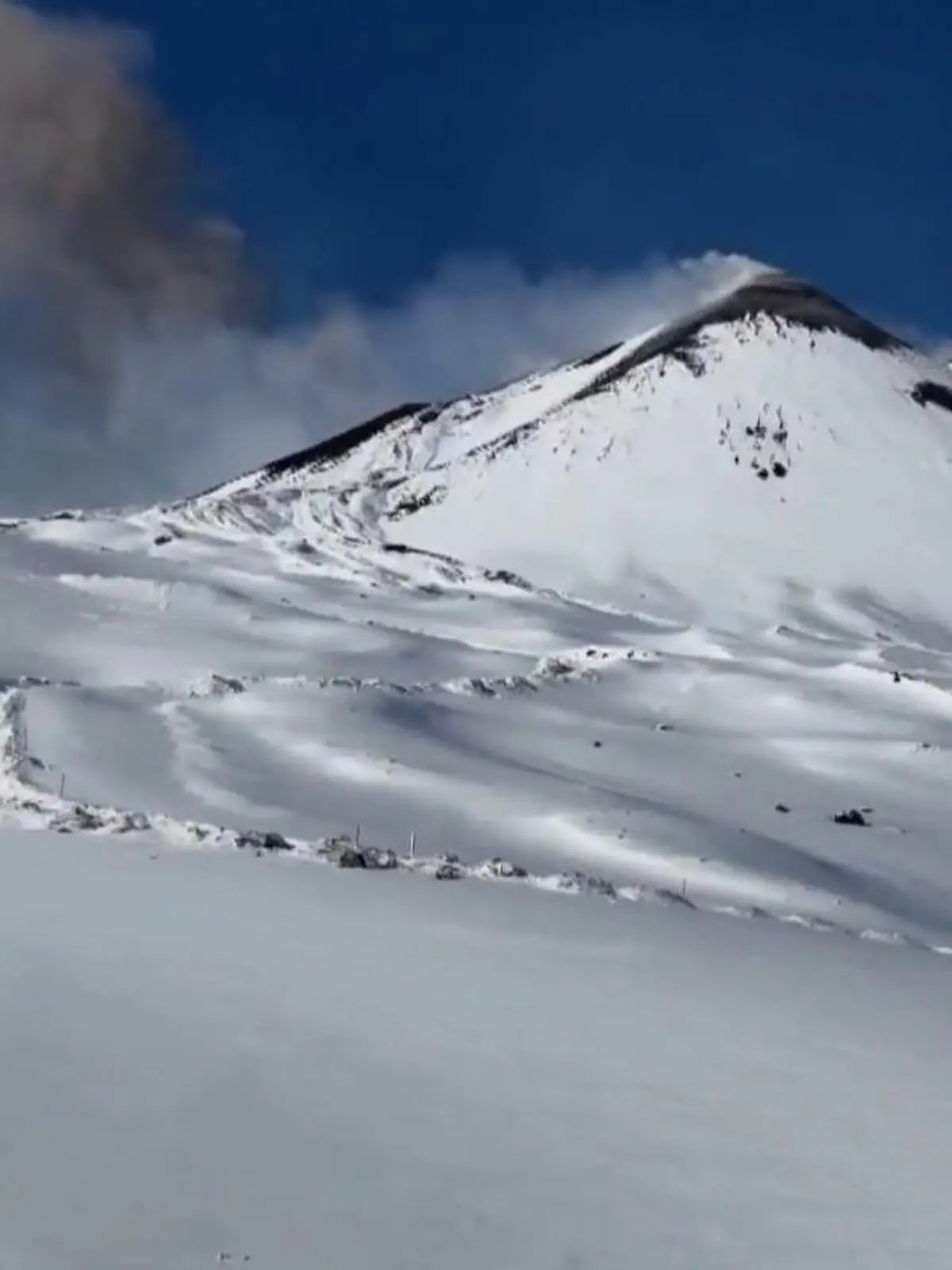 Bild zu: "Außergewöhnliche Aussicht! Skifahrer sausen vor ausbrechendem Vulkan"