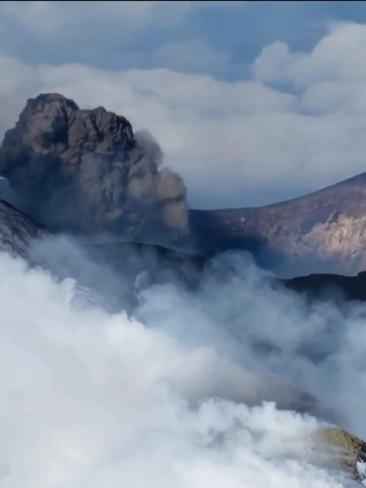 Bild zu: "Außergewöhnliche Aussicht! Skifahrer sausen vor ausbrechendem Vulkan"