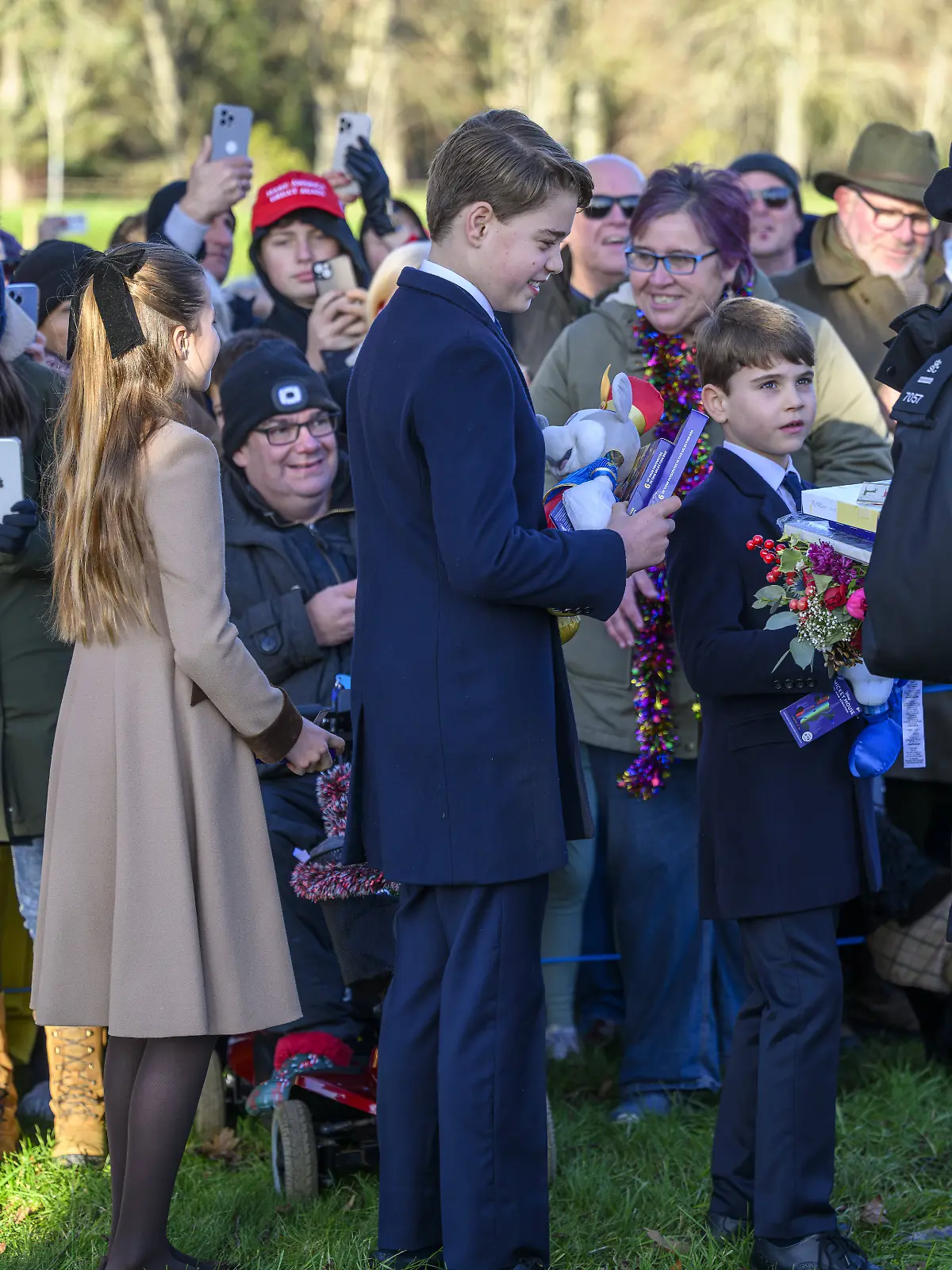 Prinz George und seine Geschwister nehmen am Weihnachtstage in Sandringham Geschenke entgegen. 