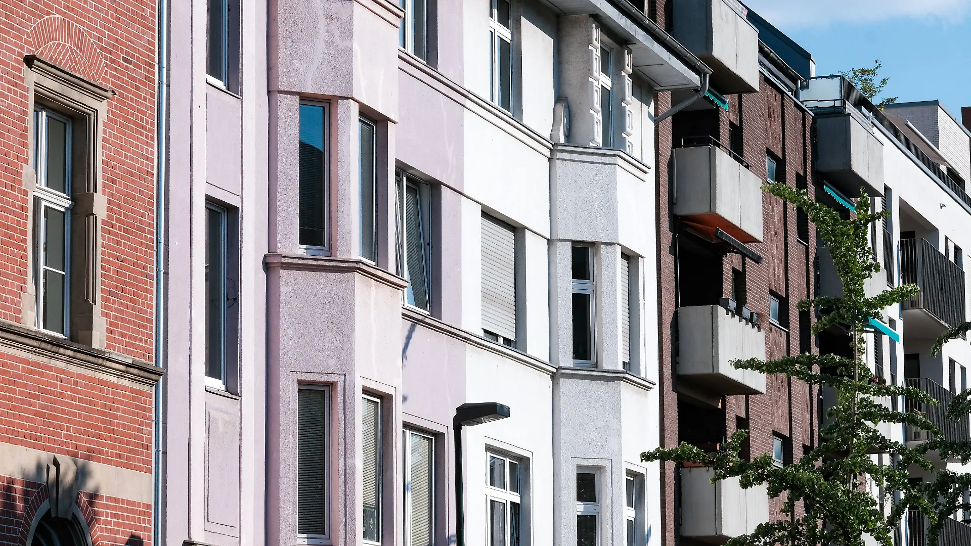 Verschiedene Wohnungsfassaden aneinandergereiht