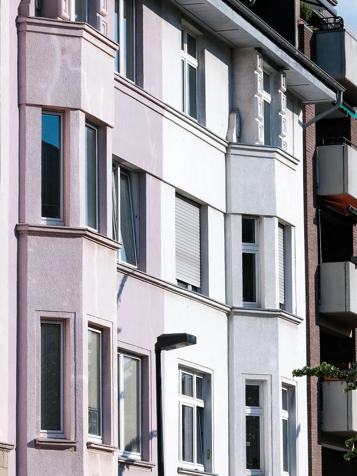 Verschiedene Wohnungsfassaden aneinandergereiht
