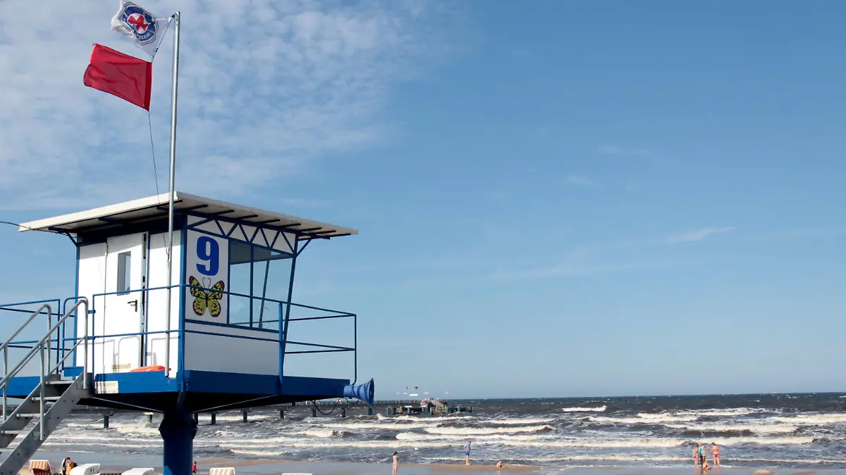 Eine rote Fahne ist am 17.08.2015 am Strand von Bansin auf der Insel Usedom (Mecklenburg-Vorpommern) über einem Überwachungsturm gehisst. Die rote Fahne kennzeichnet ein Badeverbot. Trotz Badeverbots und ausdrücklicher Ermahnungen der Rettungsschwimmer hatte sich mehrere junge Erwachsene am 17.08.2015 am Strand von Bansin in die Ostsee gewagt und gerieten in Not. Foto: Tilo Wallrodt/dpa (zu dpa KORR «Retter ärgern sich über leichtsinnige Schwimmer» vom 18.08.2015) +++(c) dpa - Bildfunk+++
