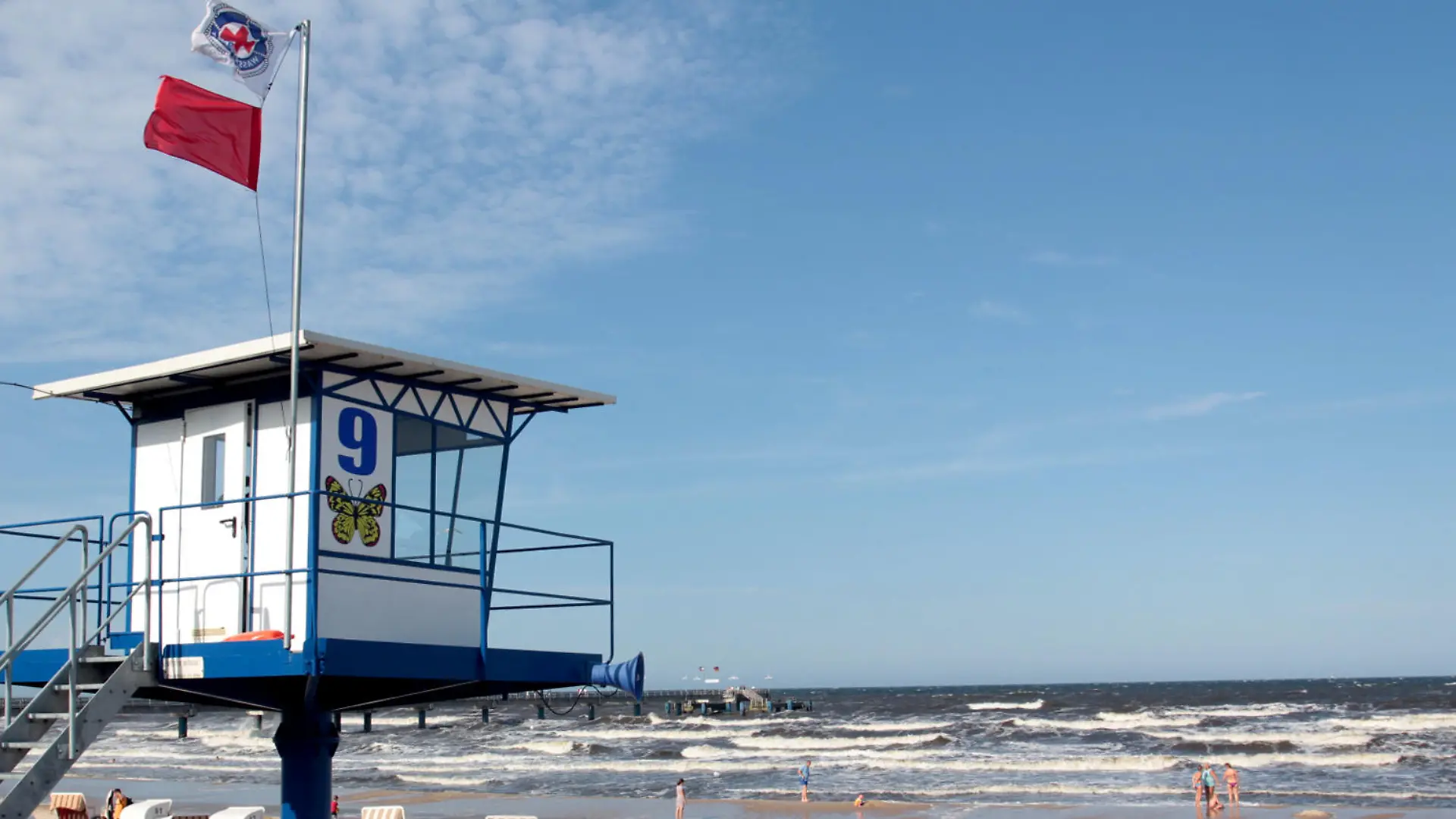 Eine rote Fahne ist am 17.08.2015 am Strand von Bansin auf der Insel Usedom (Mecklenburg-Vorpommern) über einem Überwachungsturm gehisst. Die rote Fahne kennzeichnet ein Badeverbot. Trotz Badeverbots und ausdrücklicher Ermahnungen der Rettungsschwimmer hatte sich mehrere junge Erwachsene am 17.08.2015 am Strand von Bansin in die Ostsee gewagt und gerieten in Not. Foto: Tilo Wallrodt/dpa (zu dpa KORR «Retter ärgern sich über leichtsinnige Schwimmer» vom 18.08.2015) +++(c) dpa - Bildfunk+++