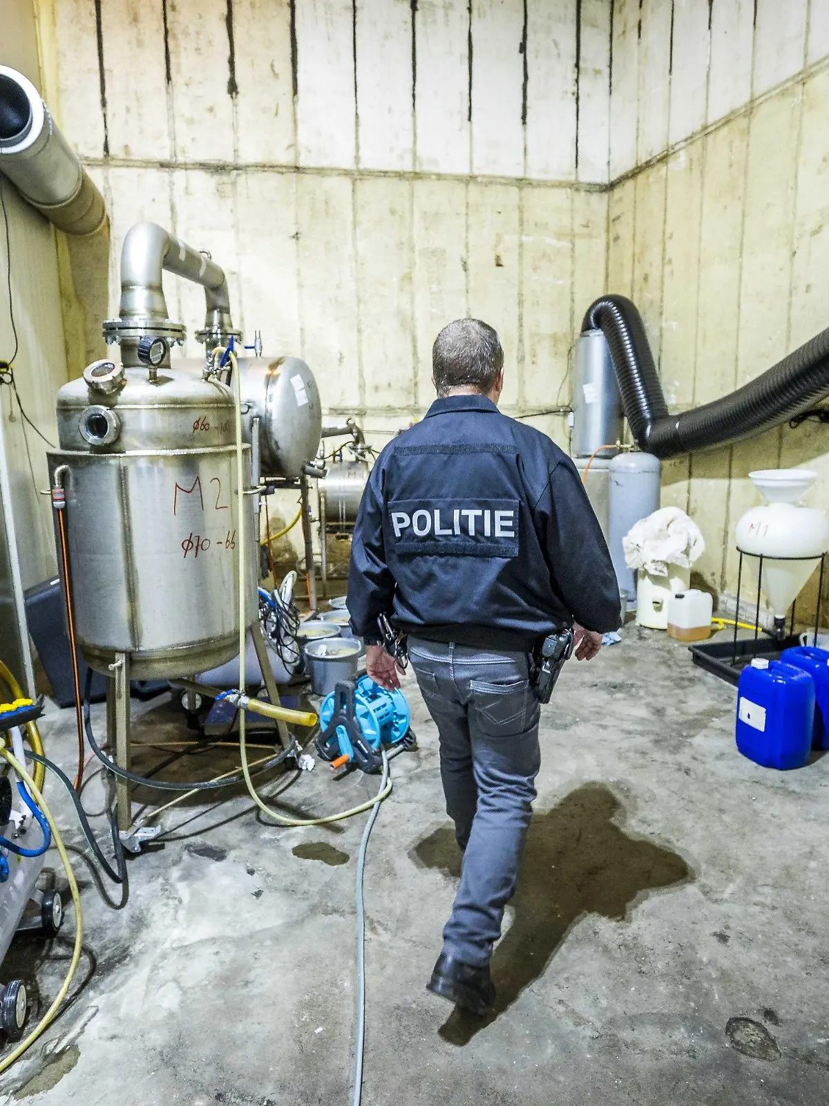30.07.2021, Niederlande, Nederweert: Ein Polizist führt Ermittlungsarbeiten in einem Crystal-Meth-Labor durch. Niederländische Ermittler haben ein großes Labor zur Herstellung der Droge Crystal Meth entdeckt. Es handele sich um «die größte und professionellste Produktionsstätte für Crystal Meth, die jemals in den Niederlanden gefunden wurde», teilte die Polizei heute in Nederweert im Südosten des Landes mit. Foto: Marcel Van Hoorn/ANP/dpa +++ dpa-Bildfunk +++