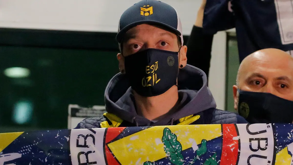 18.01.2021, Türkei, Istanbul: Mesut Özil, ehemaliger deutscher Fußball-Nationalspieler, hält nach seiner Ankunft am Atatürk-Flughafen einen Fenerbahce-Schal. Özil verlässt nach siebeneinhalb Jahren den FC Arsenal und wechselt zu Fenerbahce Istanbul in die türkische Süper Lig. Foto: Uncredited/AP/dpa +++ dpa-Bildfunk +++