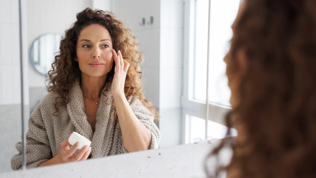 Frau trägt im Bad Creme auf