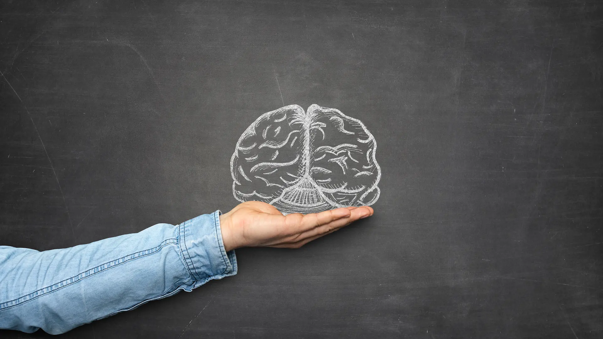 Brain and hand front of blackboard