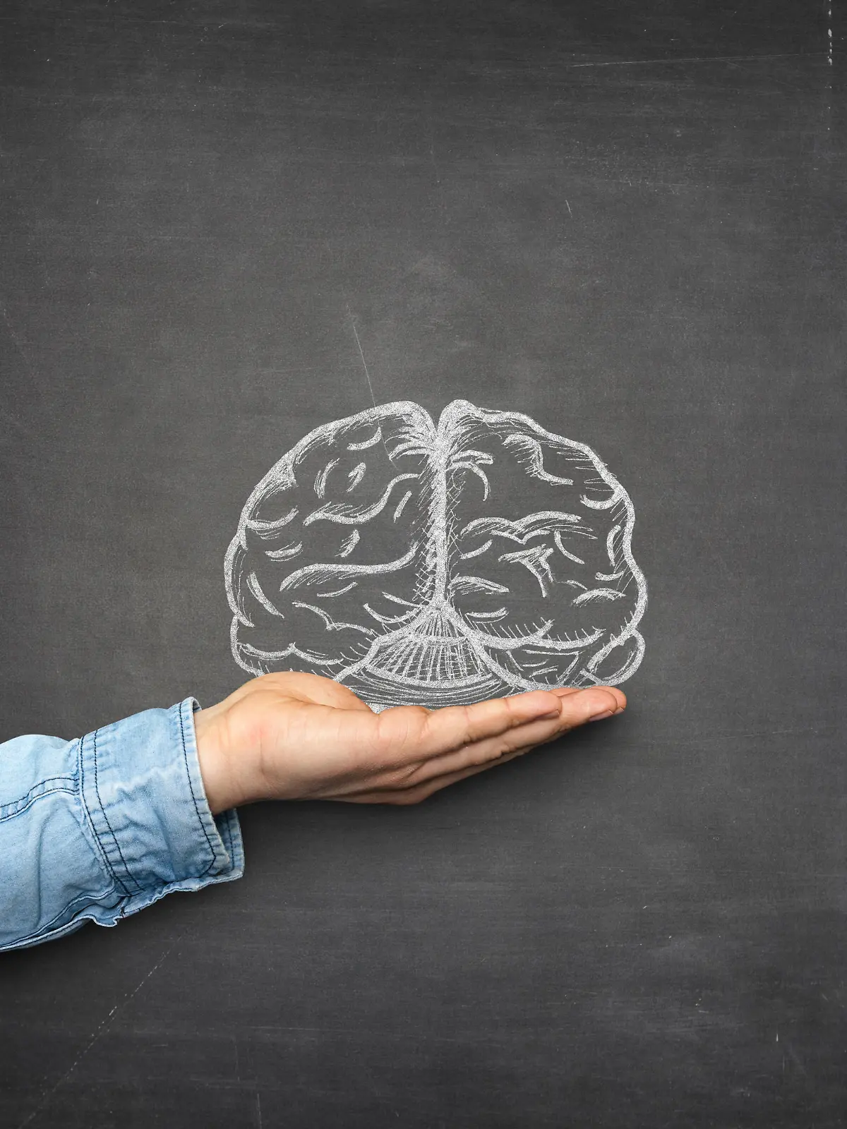 Brain and hand front of blackboard