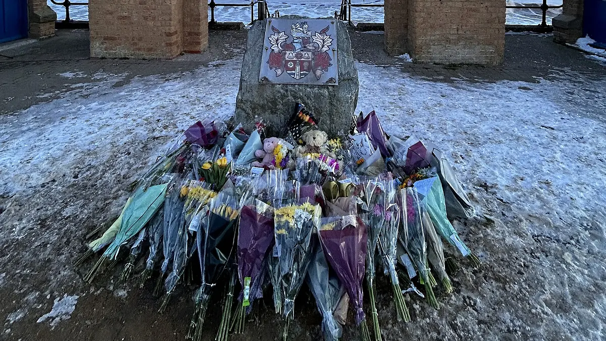 Ruine mit Blumen und Kuscheltieren im Vordergrund.