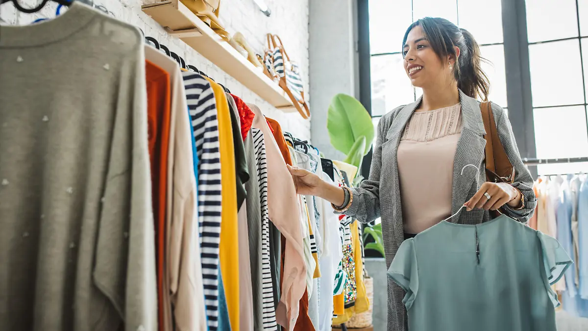 Young woman shopping clothes in thrift store.