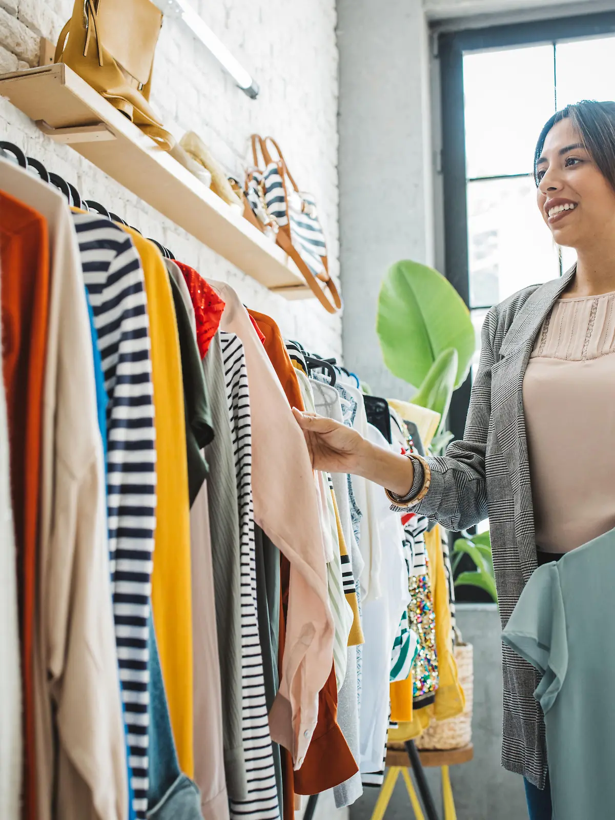 Young woman shopping clothes in thrift store.