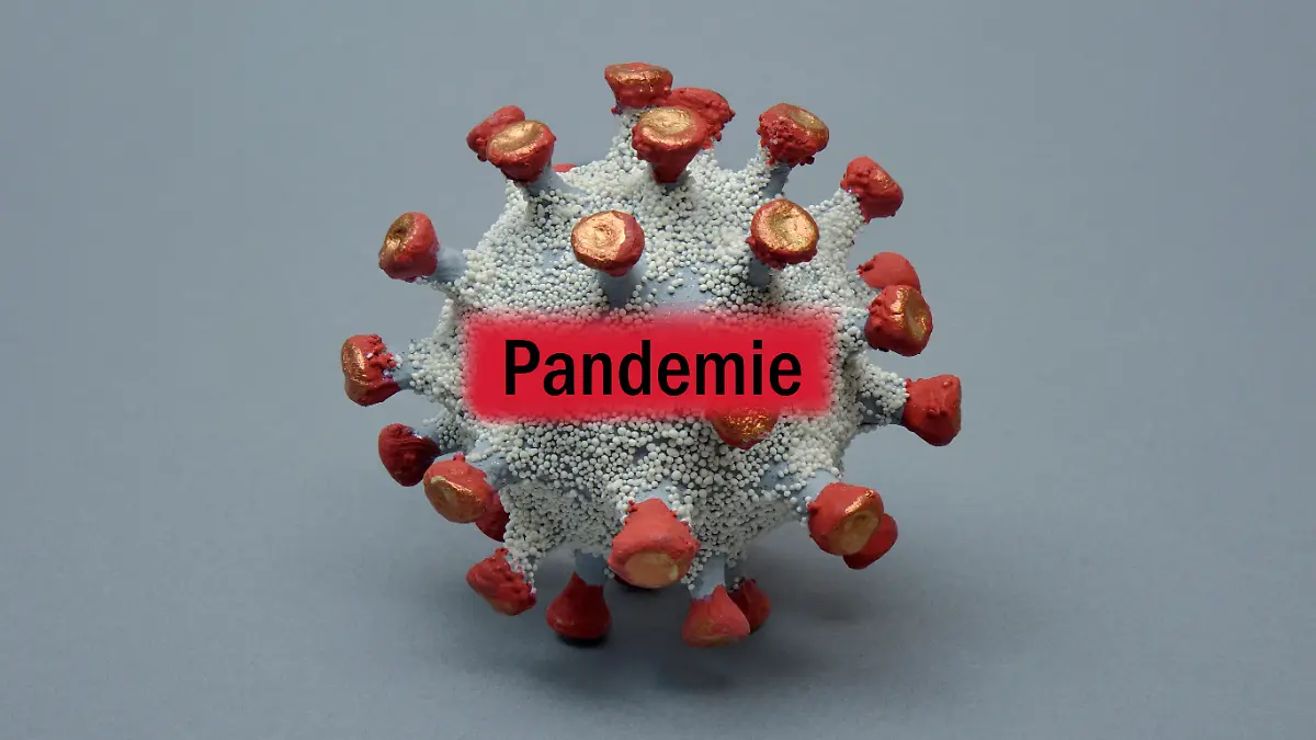 Virusmodell mit dem Schriftzug Pandemie (Montage)