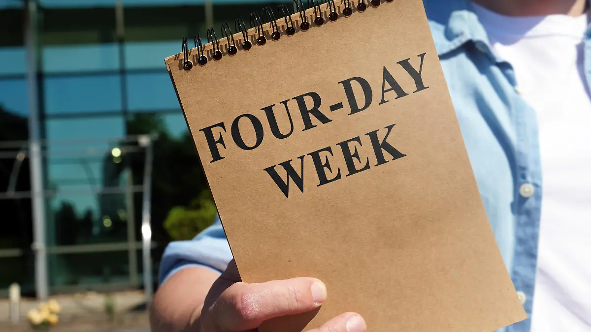 The Man proposes four-day week sign. Notepad in hand.